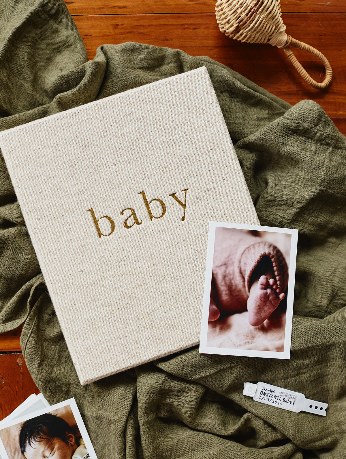 Oatmeal linen baby book with a polaroid of a newborn