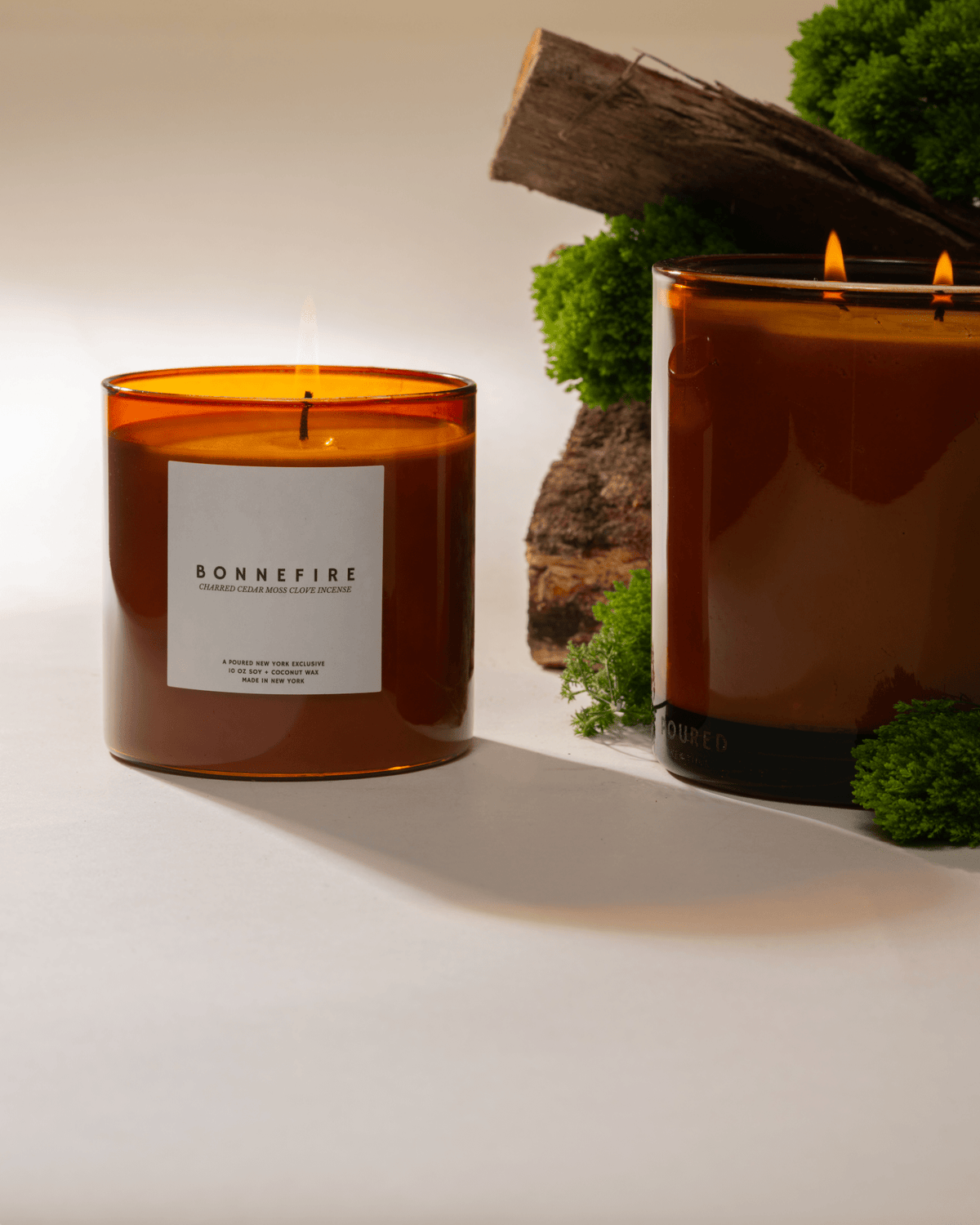 Two lit Bonnefire candles with moss and wood