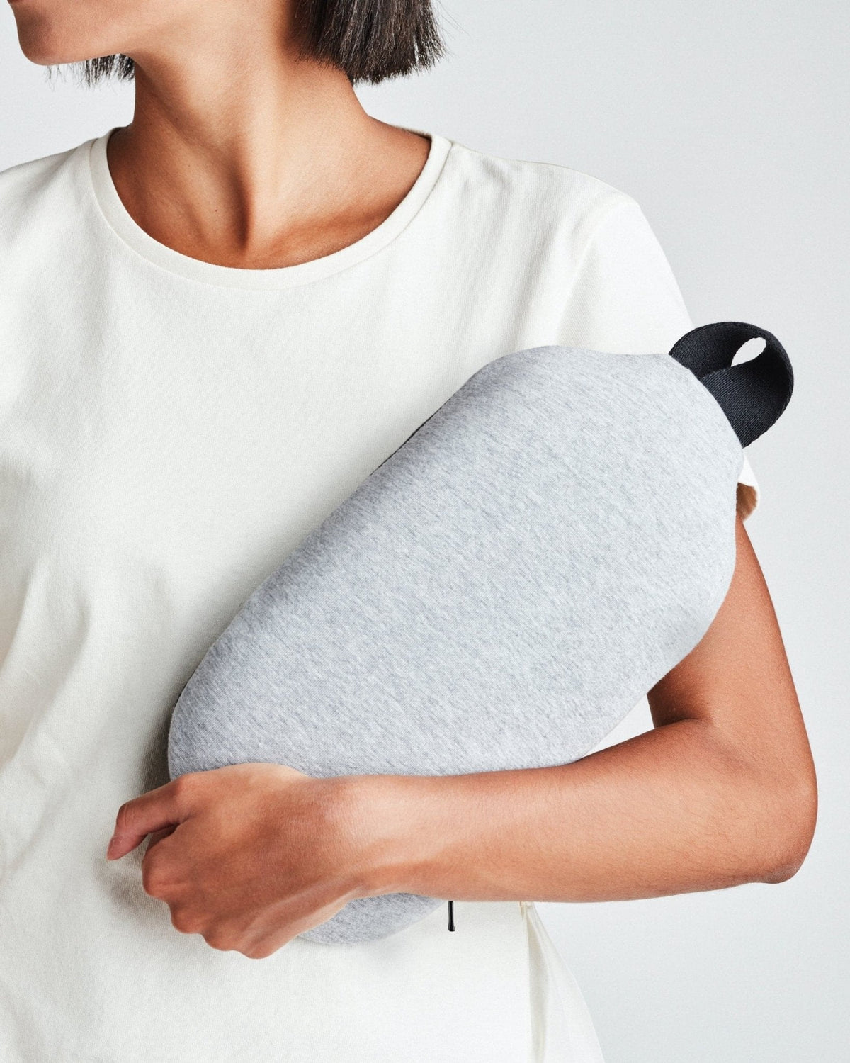 Ostrichpillow Heatbag in midnight grey, held in one arm