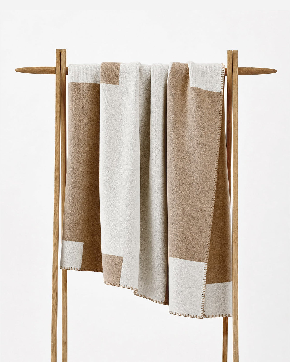 The throw on a stand, showing the blocked tan and off white
