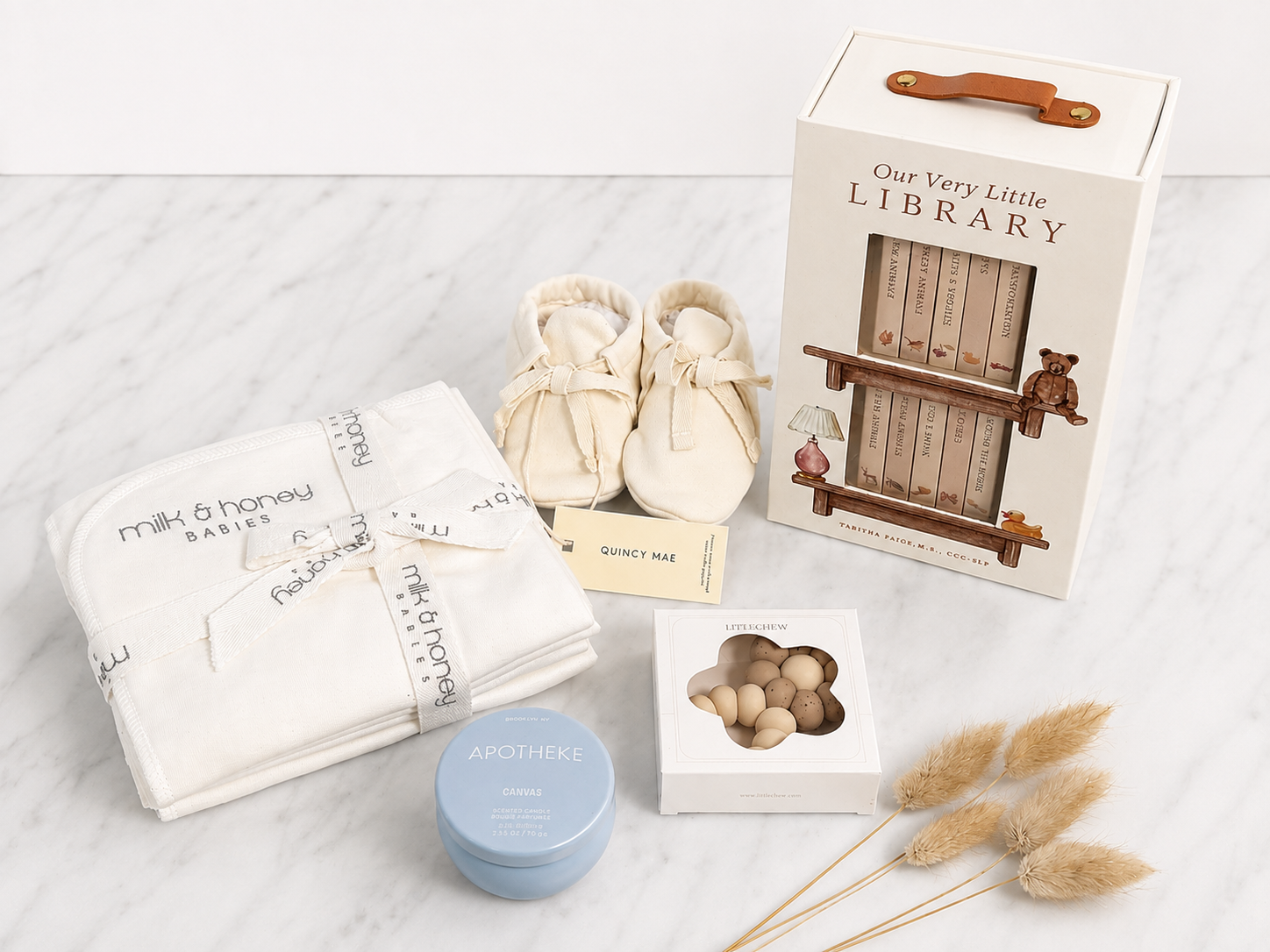 The Welcome Edit with organic burp cloths, undyed booties, littleCHEW teether, Apotheke Canvas candle, and Our Very Little Library board book set